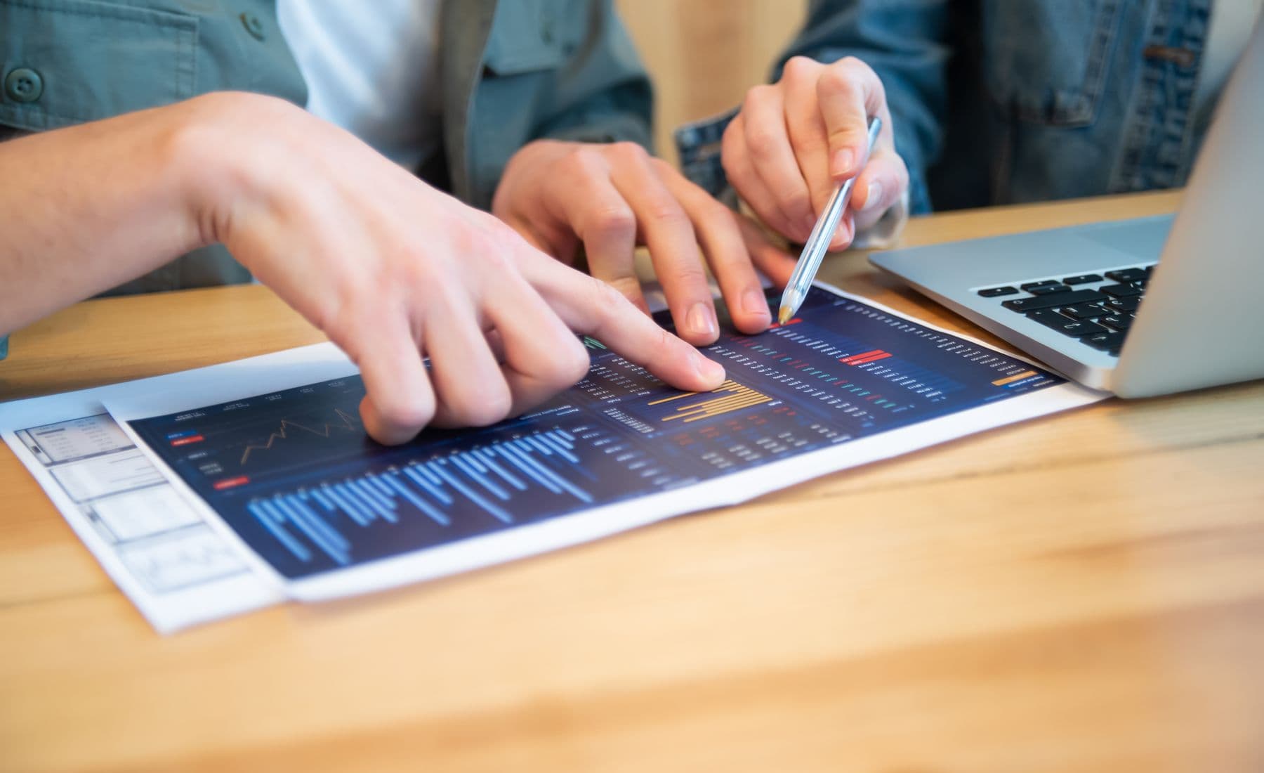 Business advisors reviewing financial projections and a laptop together.