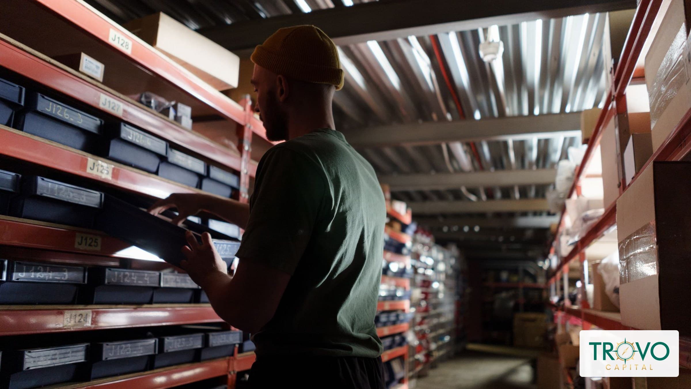Retail shop owner checking ceramic inventory on stockroom shelves