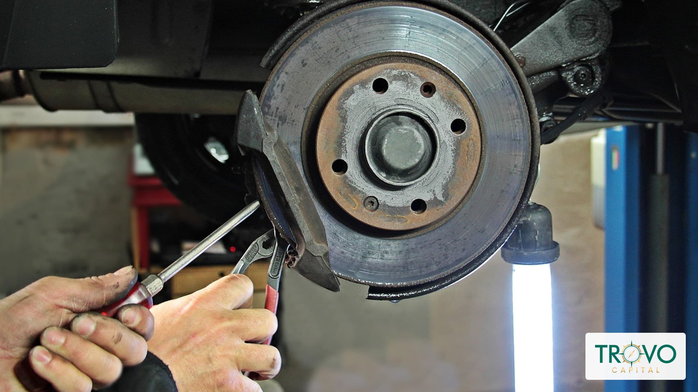 A bicycle shop owner explains a brake repair to a customer outside the workshop