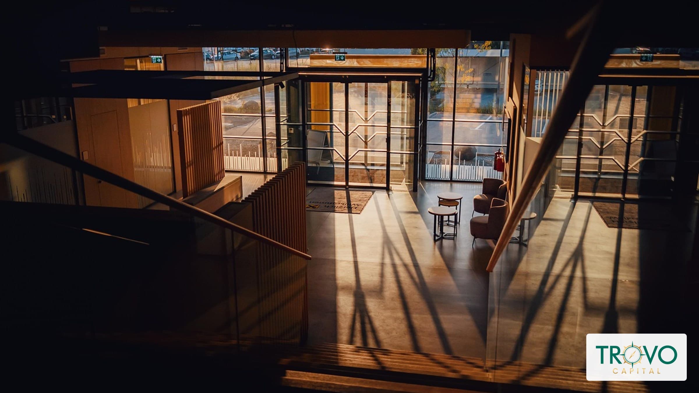A customer entering a modest, unbranded bank branch through glass doors.