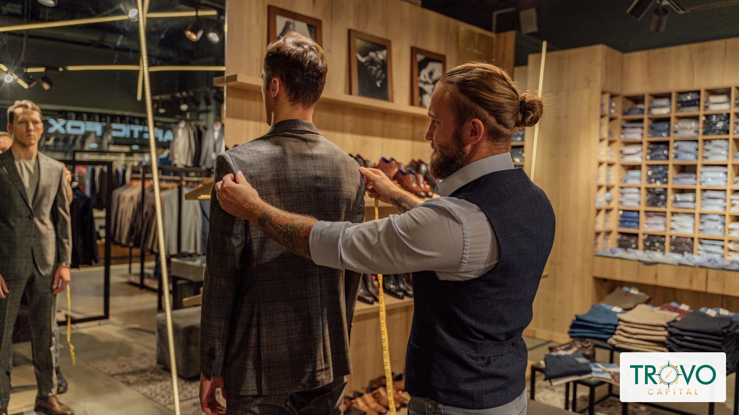 Tailor checking a jacket’s fit with a customer in a modest alterations shop