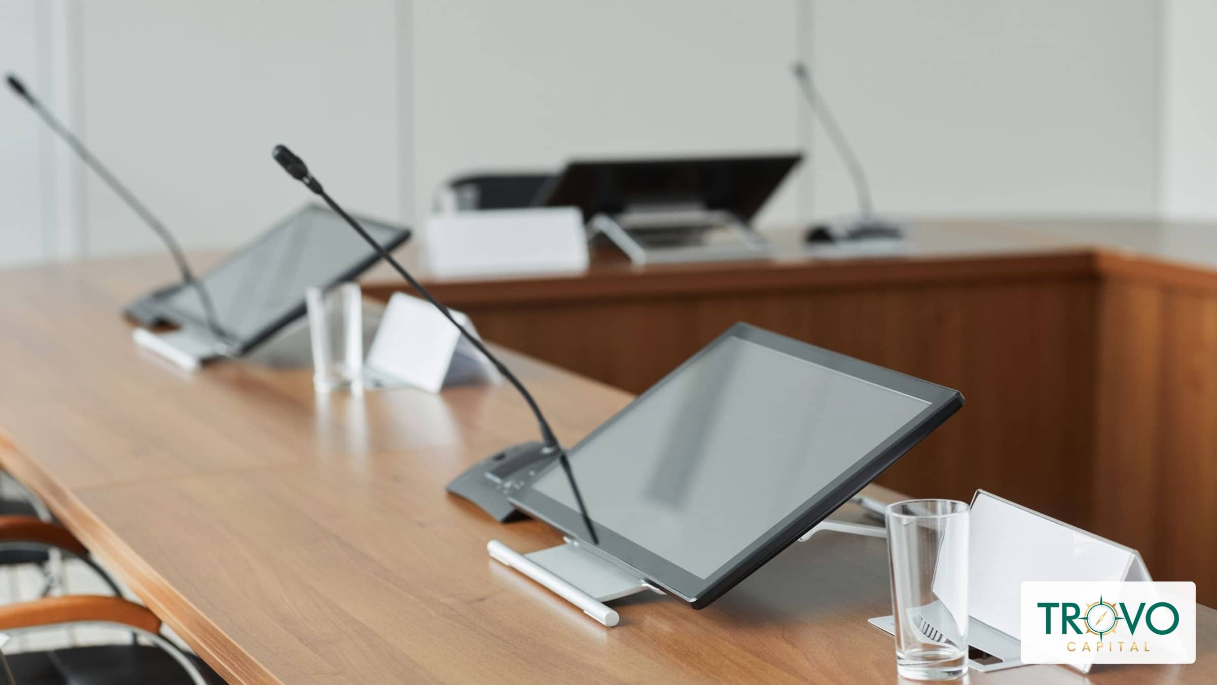Empty conference room with tabletop microphones and chairs after a meeting