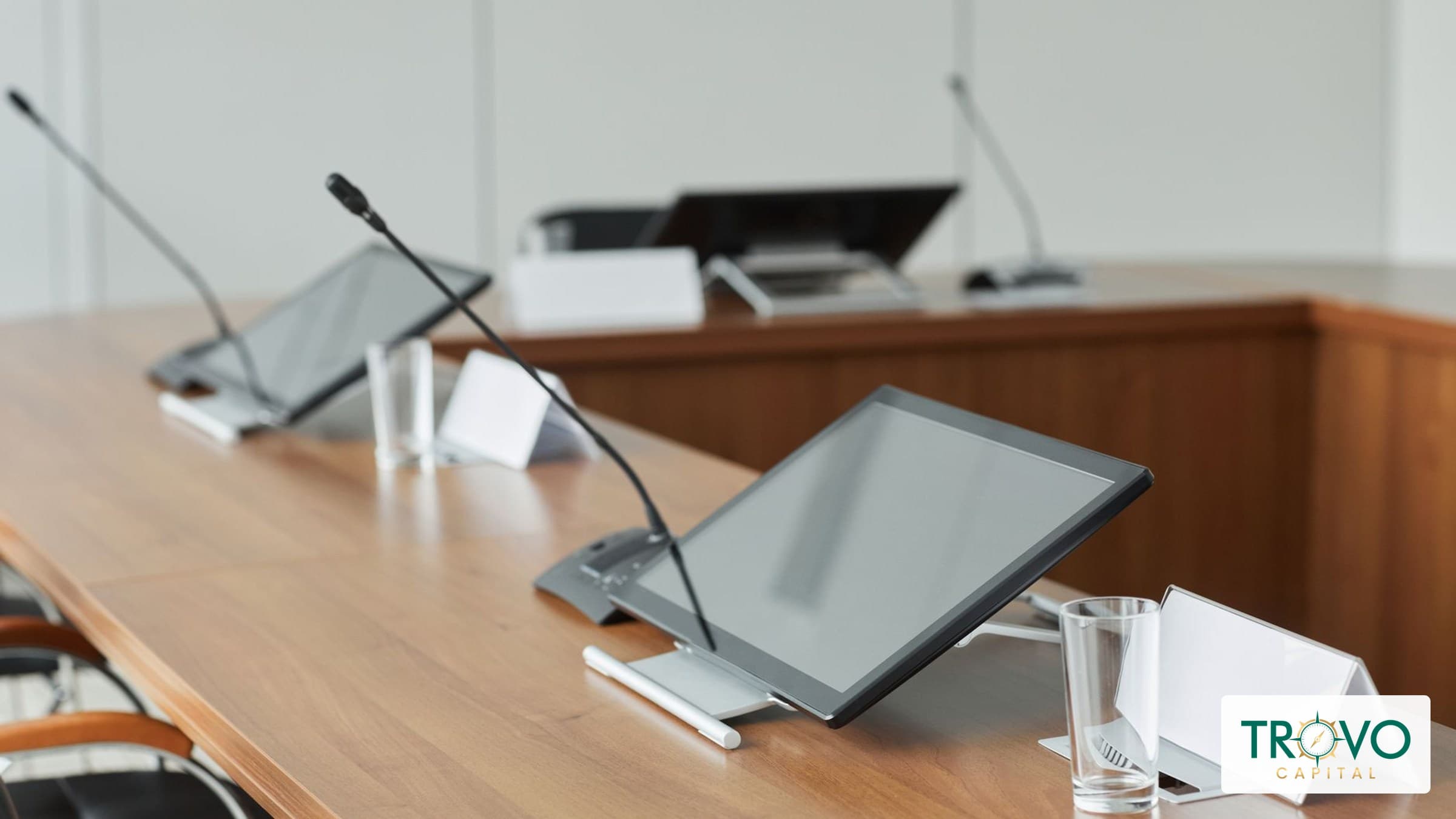 Empty conference room with tabletop microphones and chairs after a meeting